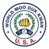 A circular emblem featuring a golden fist surrounded by laurel leaves, with text indicating "World Moo Duk Kwan" and "U.S.A."